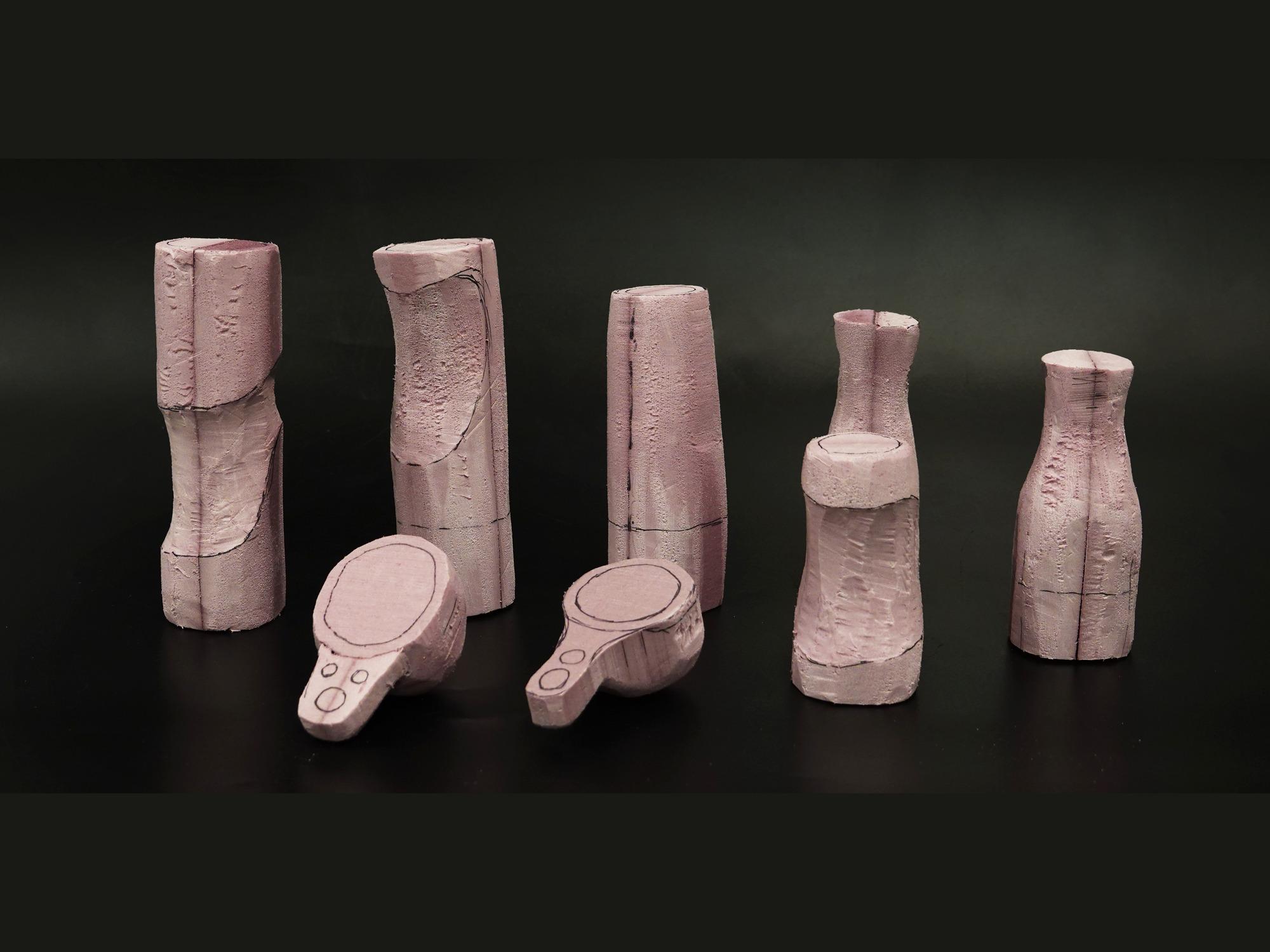 Row of hand-carved foam grip models exploring different body shapes